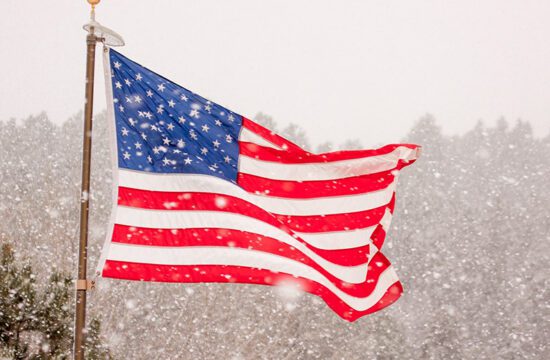 American flag with snow in the foreground and background