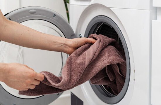 hands pulling a towel out of a small washing machine
