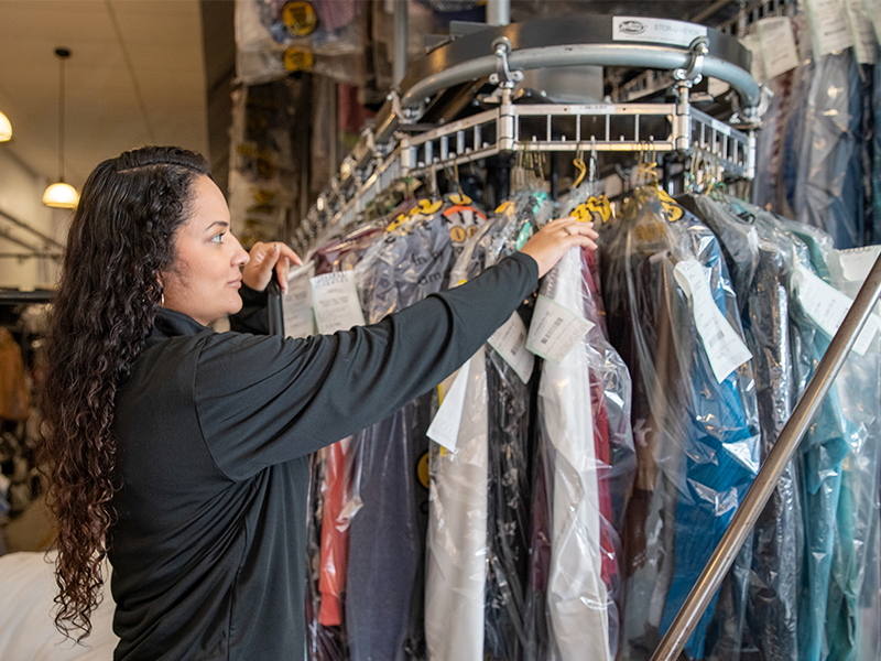 Rack of clean clothes hanging on hangers at dry-cleaning Stock Photo