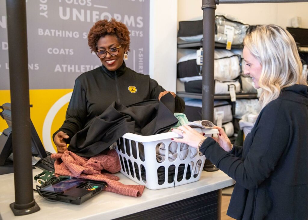 Zips employee helping customer with clothing